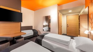 Una habitación de hotel moderna con una cama grande, un escritorio y un espejo.