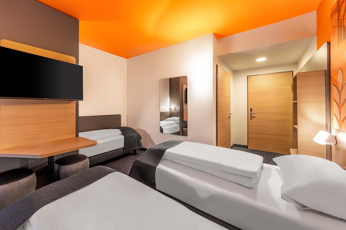 Une chambre d’hôtel moderne, dotée d’un grand lit, d’un bureau et d’un miroir.