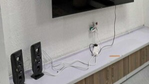 Un téléviseur à écran plat fixé à un mur blanc, avec un meuble en bois placé en dessous.