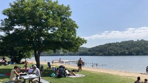 A lakeside park with picnic tables, a playground, and a beach area. - Unusual nights on a 12m boat in the heart of nature (Loire gorges)  (Bully)