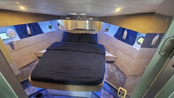 A compact, modern room with a bed, a small table, and a mirror. - Unusual nights on a 12m boat in the heart of nature (Loire gorges) (Bully)
