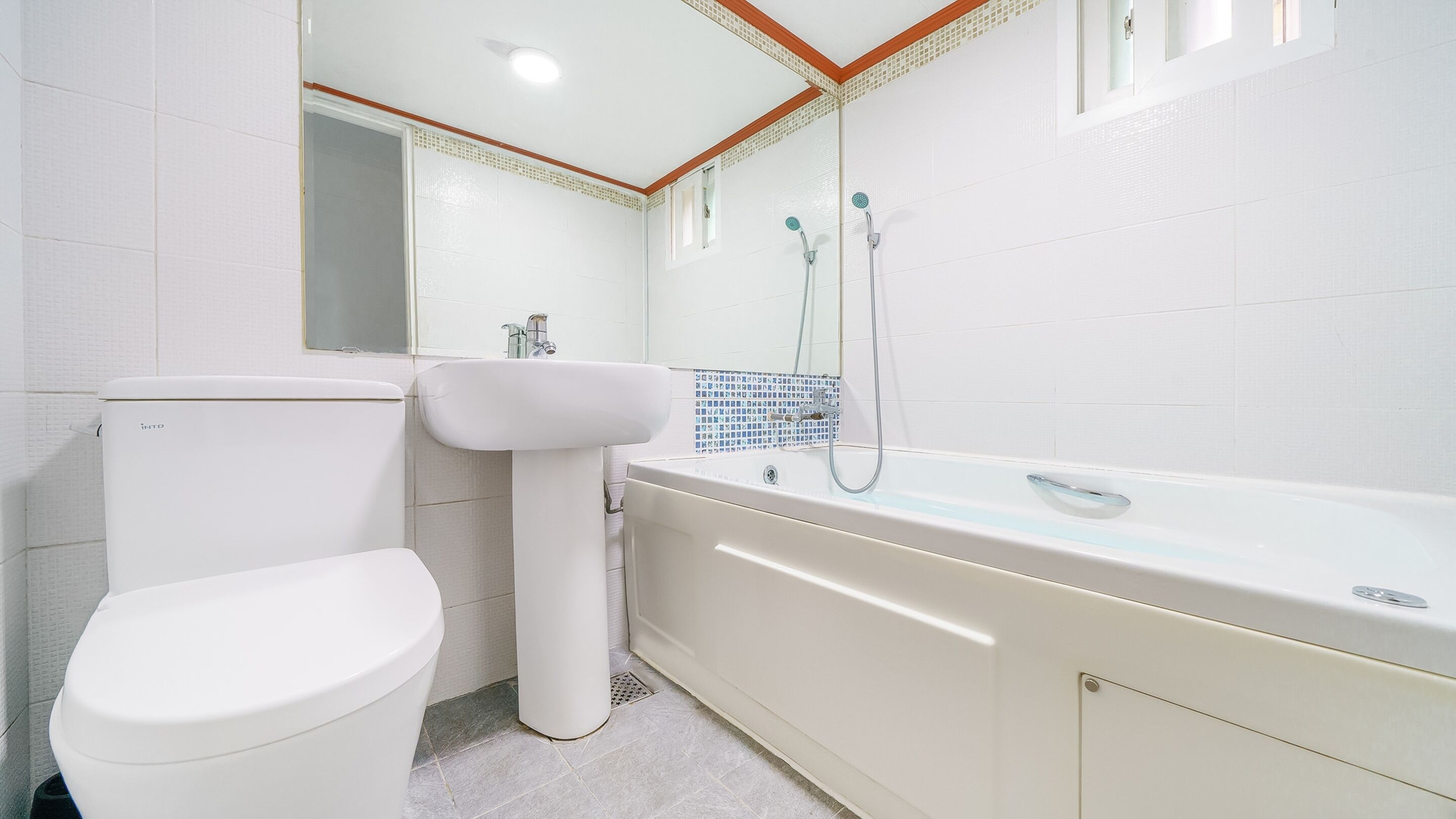 A bathroom with a toilet, sink, and bathtub.