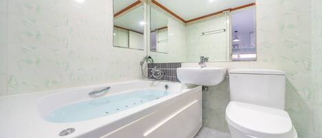 A bathroom with a bathtub, a sink, and a toilet.