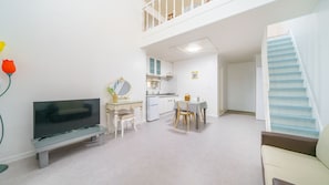 Eine moderne Wohnung mit Wohnzimmer, Essbereich, Küchenzeile und einer Treppe.