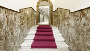 A marble staircase with a red carpet, gold handrails, and a view into a hallway. - Domus Augustea - Nerone (Rome)