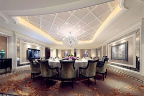 A spacious dining area with a high ceiling and chandelier, surrounded by comfortable chairs and a central table. - Joyful Hotel (Yueqing)