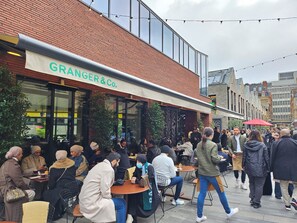 A cafe named GRANGER&CO. with outdoor seating and a brick facade. - Elegant Apartment in Chelsea, Kensington (London)