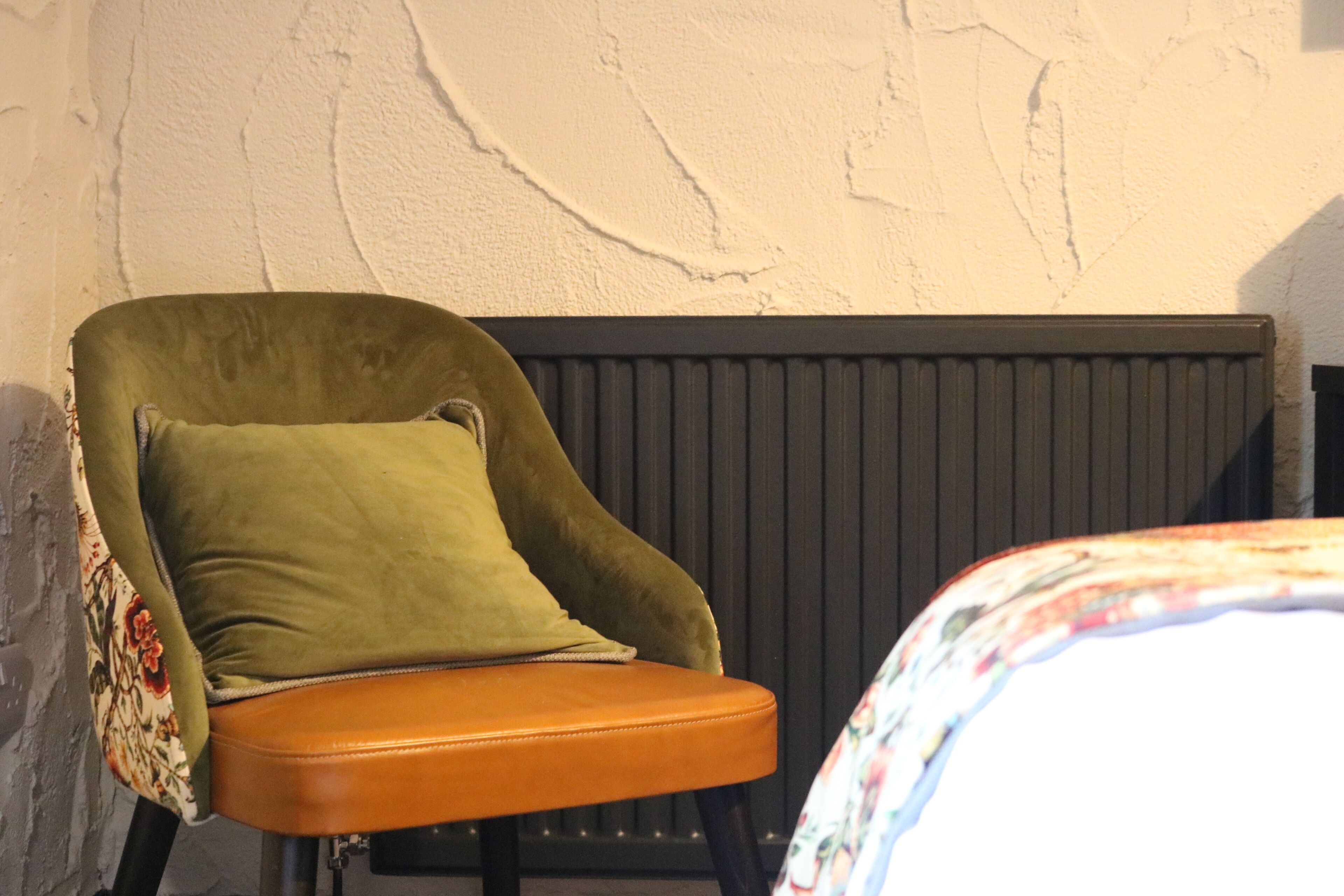 A chair with a cushion and a radiator in the background.