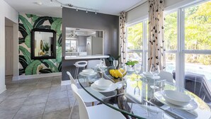 A modern dining area with a glass table, white plates, and a yellow bowl. - BRIGHT Fort Lauderdale Tropical Retreat (Fort Lauderdale)