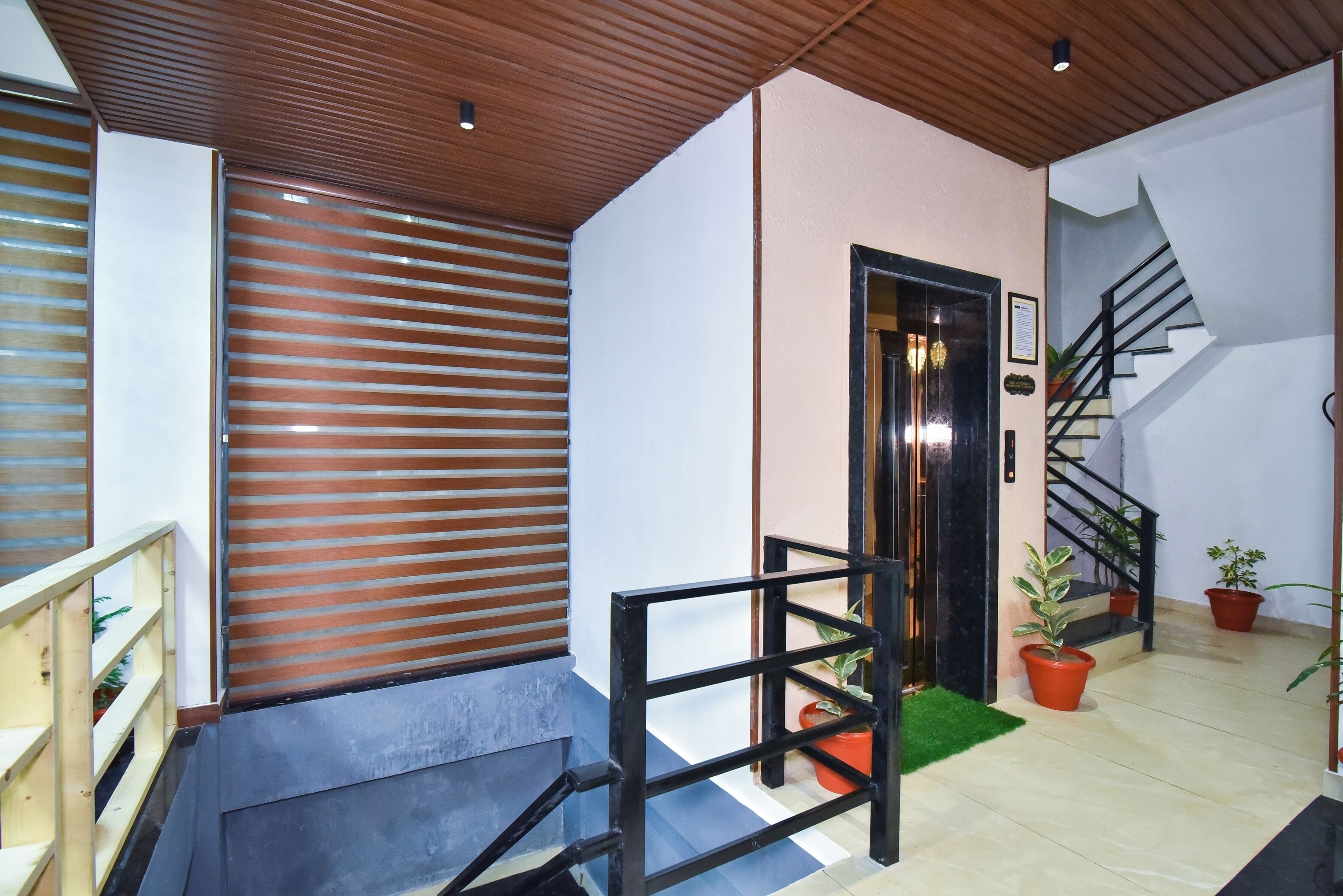 Un interior moderno con techo de madera, una escalera y plantas en macetas.