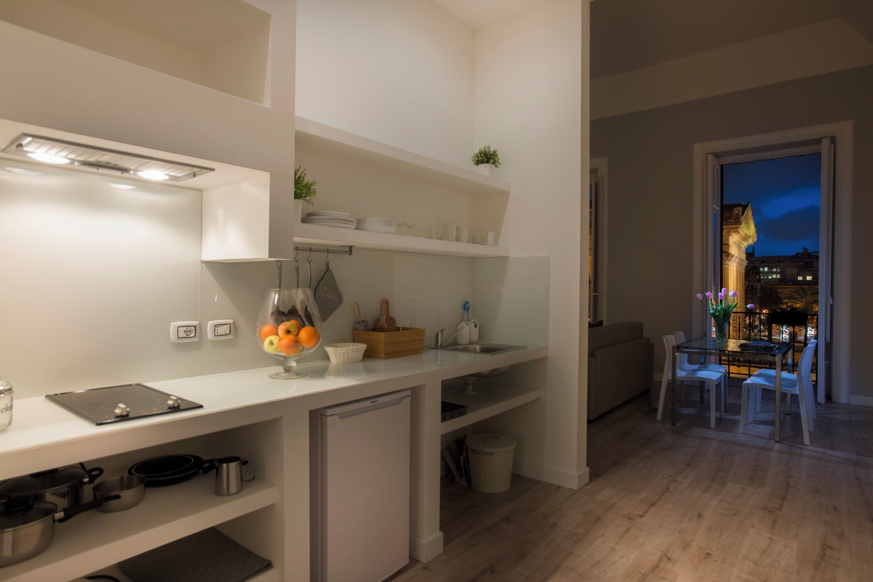 Eine moderne Küche mit weißen Schränken, einem eingebauten Backofen und einem Essbereich mit Tisch und Stühlen.