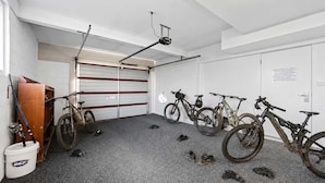 A garage with bicycles, a wooden door, and a white bucket. - Residential Retreat, Groups & Families-Sleeps 15 (Warrane)