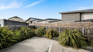 A residential area with a paved courtyard surrounded by fences and houses. - Residential Retreat, Groups & Families-Sleeps 15 (Warrane)