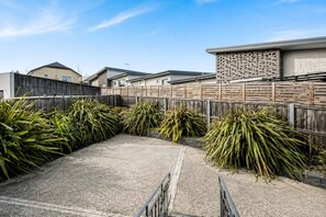 Zona residencial con un patio empedrado rodeado de cercas y casas.
