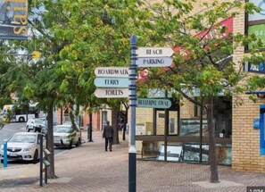 A street sign with directions to various locations including Beach, Boardwalk, Ferry, Toilets, and Helshire Oval.