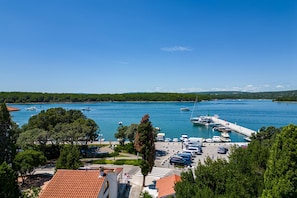 A marina with boats docked, a parking area, and a view of the water. - Seafront Apartment Nana 1 (Punat)