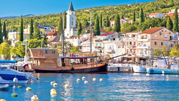 A harbor with boats, a prominent clock tower, and buildings with balconies. - Pool House Beba Tribalj Lake (Vinodol)