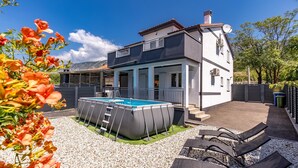A two-story house with a swimming pool, a covered patio, and a fenced backyard. - Pool House Beba Tribalj Lake (Vinodol)