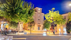 A public square with steps leading up to a building with a clock tower, surrounded by trees and outdoor seating. - Pool Villa Cupido in Crikvenica - Drivenik (Vinodol)