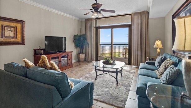 A living room with a television, two sofas, a coffee table, and a large window with a view.