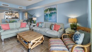 Ein Wohnzimmer mit zwei Sofas, einem Couchtisch und einem Essbereich mit Tisch und Stühlen.