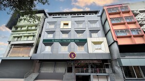 A multi-story building with a sign for "Sumitell Premiere Inn" and a logo above the entrance. - Sumitel Premier Inn (Siliguri)