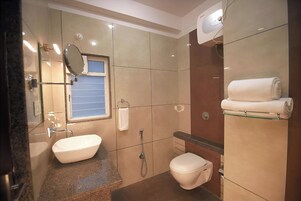 Un baño moderno con lavamanos, inodoro y ducha.