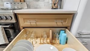 A kitchen drawer with neatly organized dishes and utensils. - Water Street Hideaway (Wilmington)