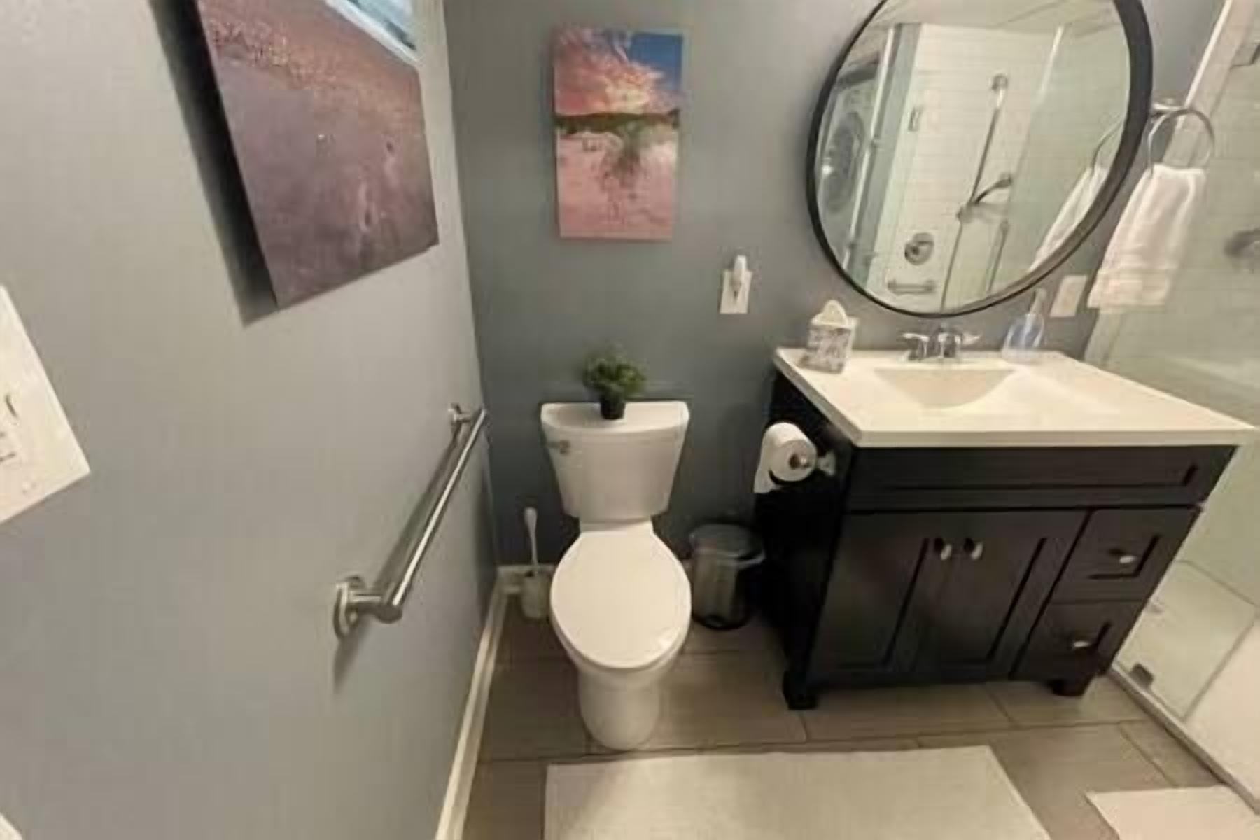 Un bagno con il water, un lavandino e uno specchio.