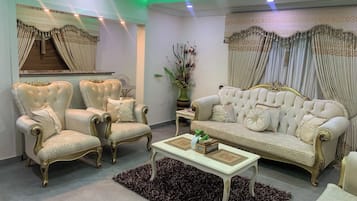 Habitación económica, balcón, vista a la ciudad | Área de sala de estar