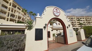 Ingången till El Paso Bar Restaurant, med fri utsikt över byggnadens arkitektur och de omgivande palmerna.