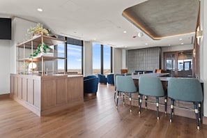 Una cocina moderna con una isla central, asientos tipo bar y vistas a la ciudad.