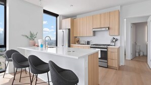 Una cocina moderna con una isla central, electrodomésticos de acero inoxidable y armarios de madera.