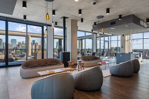 A modern office space with large windows, comfortable seating areas, and a city view.