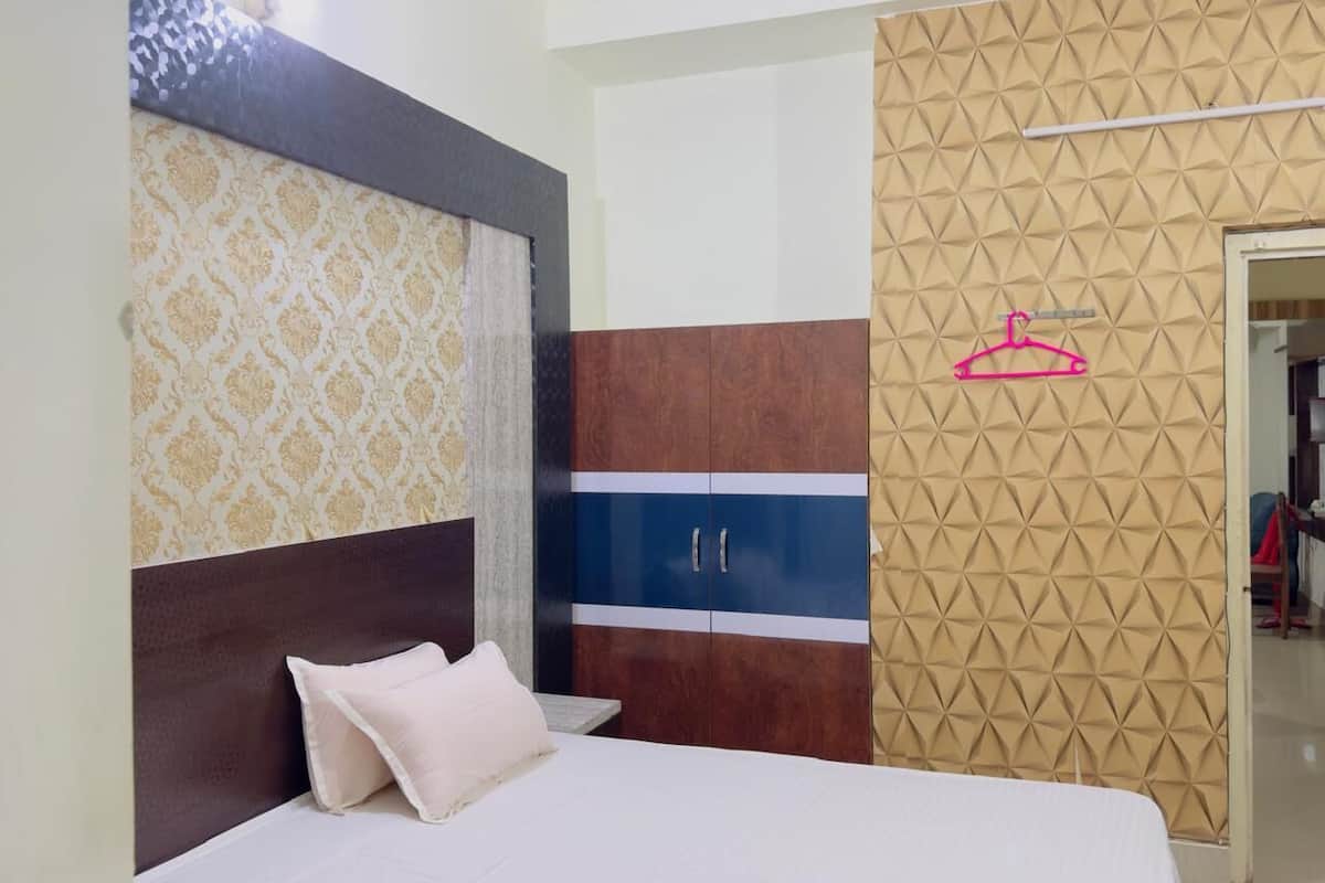Quarto com cama, guarda-roupa e parede estampada.