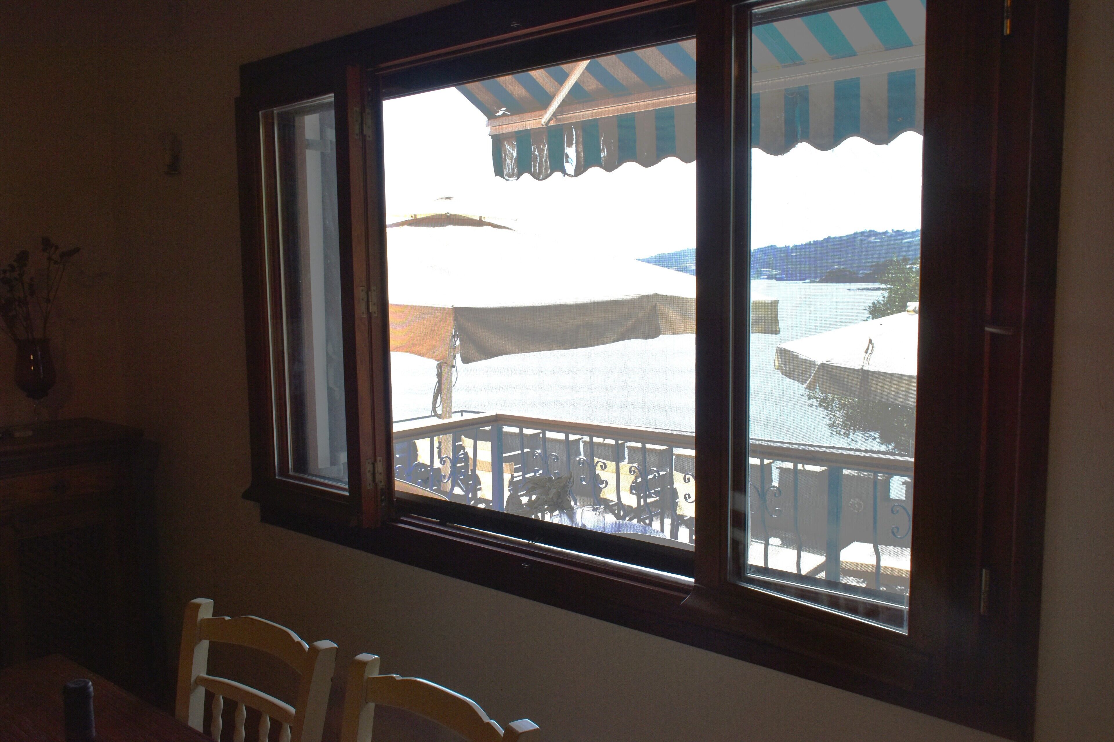 A room with a large window overlooking a balcony with outdoor furniture.