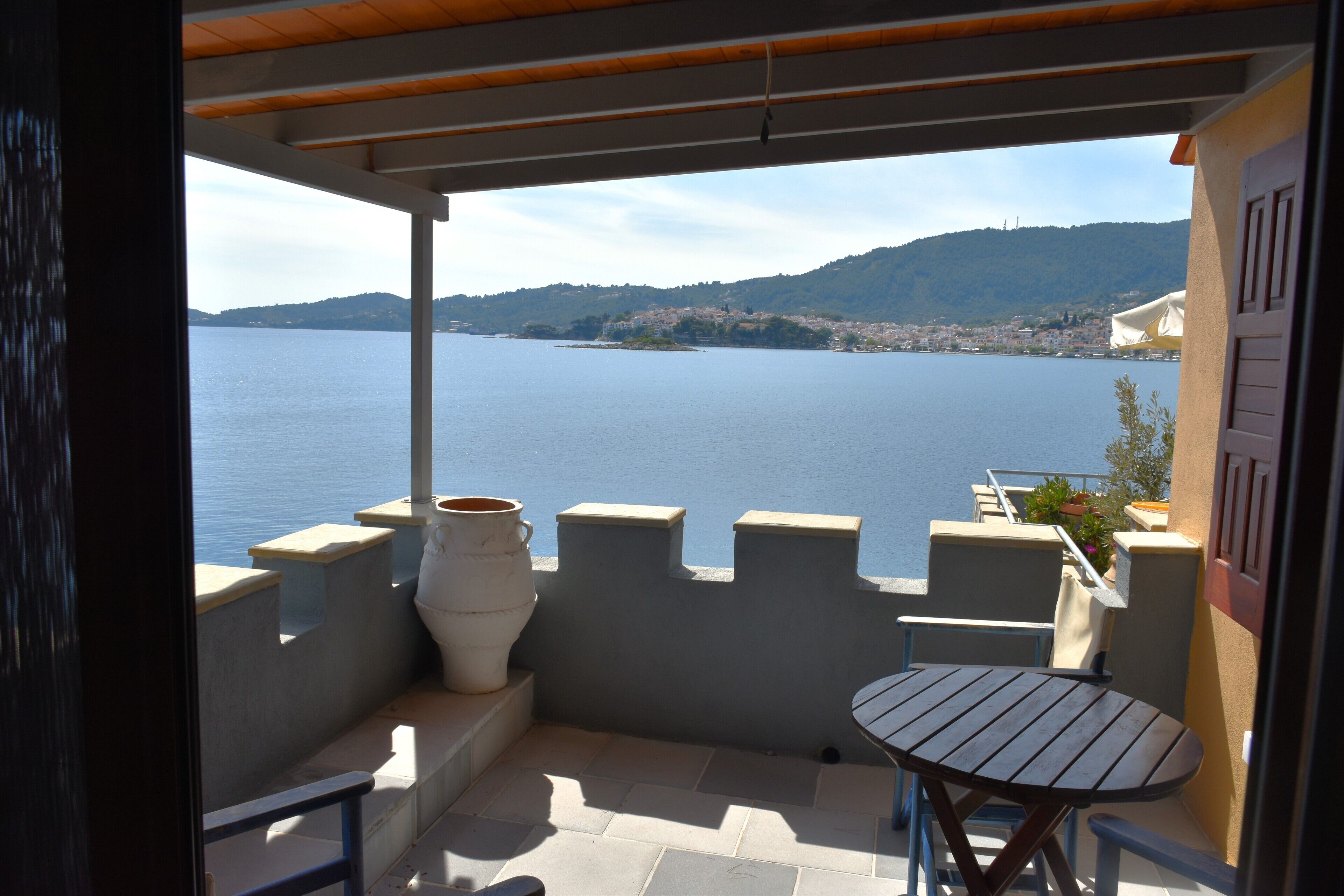 A balcony with a view of a large body of water and a distant cityscape.