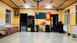 A spacious room with a polished floor, a television mounted on the wall, and a brick accent wall. - Xuegushanliren (Wuchang)