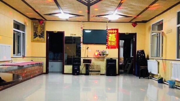 A spacious room with a polished floor, a television mounted on the wall, and a brick accent wall. - Xuegushanliren (Wuchang)