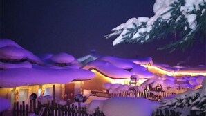 A snow-covered landscape with a wooden fence and a building with a warm light. - Xuegushanliren (Wuchang)