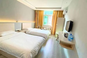 A hotel room with two beds, a desk, a chair, a TV, and a window with curtains. - Changting Peace Hotel (Changting)