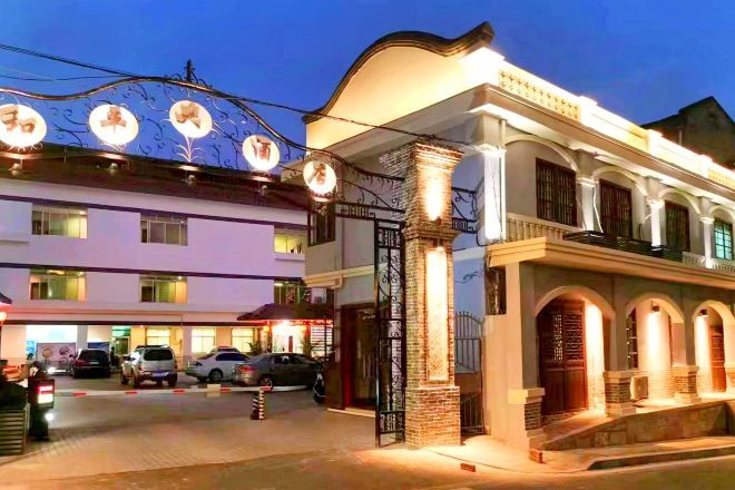 A hotel with a traditional architectural style, featuring arched windows and a prominent entrance gate.