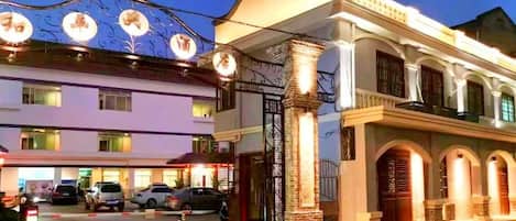 A hotel with a traditional architectural style, featuring arched windows and a prominent entrance gate.