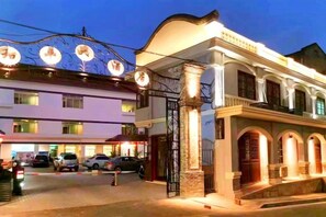 A hotel with a traditional architectural style, featuring arched windows and a prominent entrance gate.