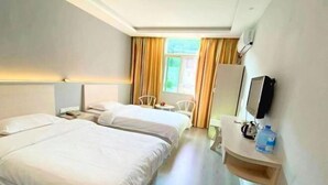 A hotel room with two beds, a desk with a chair, a television, and a window with curtains. - Changting Peace Hotel (Changting)