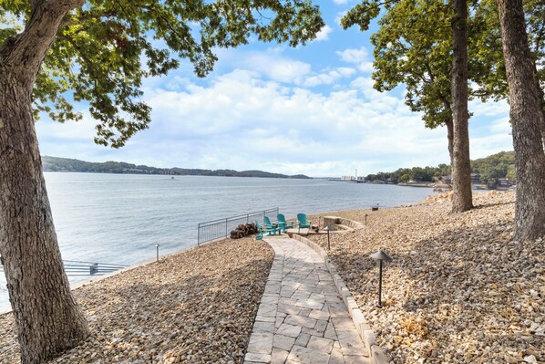 Stroll down the peaceful stone path to a cozy lakeside fire pit. - Pet-Friendly Home In The Main Channel w/ Breathtaking Sunsets & Lake Views (Lake Ozark)