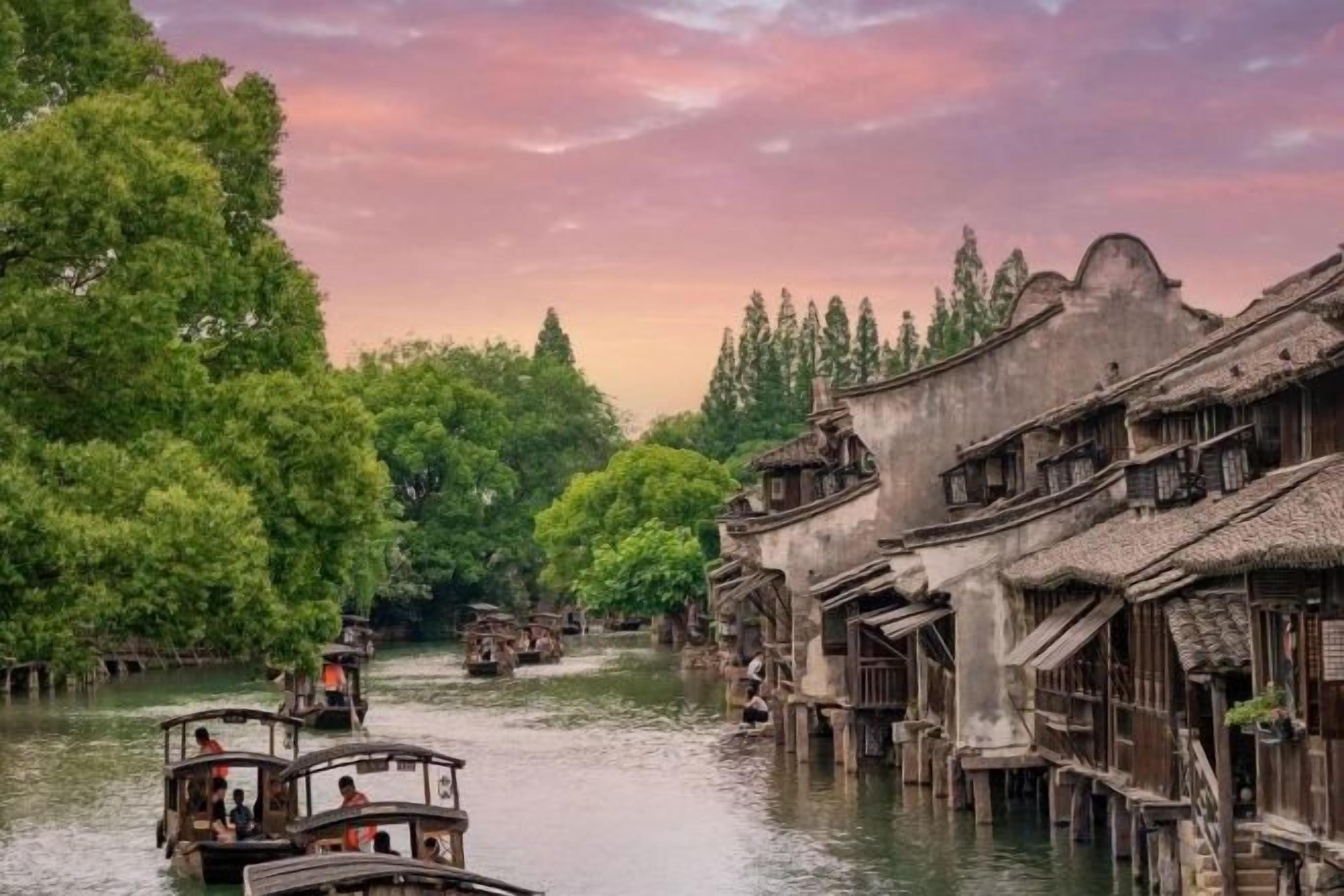 Un pueblo tradicional a orillas del río, con edificios de madera y barcos en el agua.