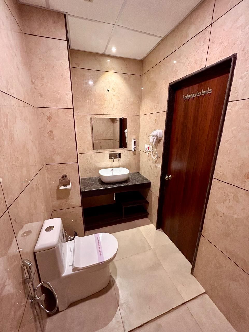 A modern bathroom with a toilet, sink, and mirror.