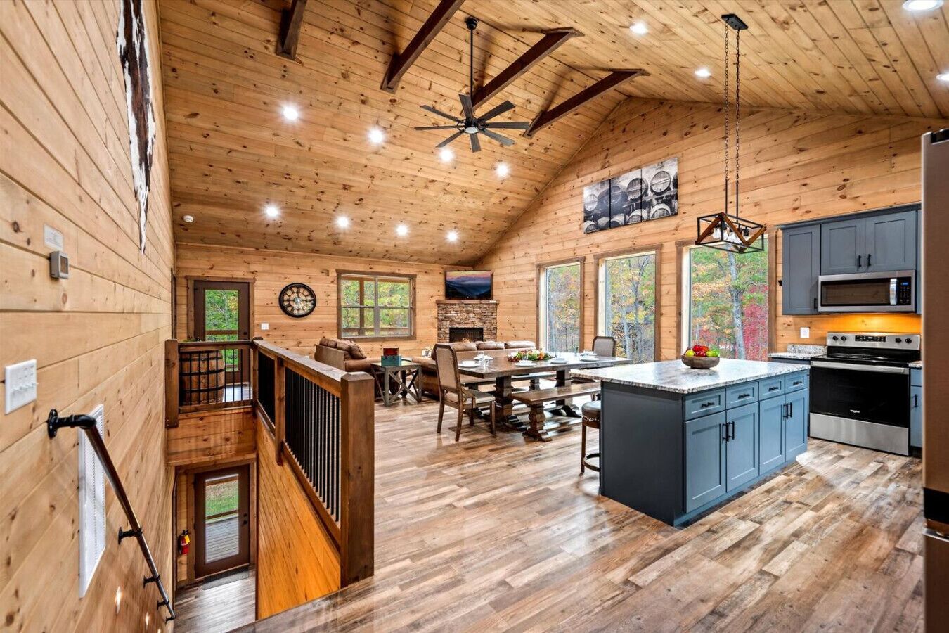 Un intérieur de cabine spacieux, avec un revêtement en bois, un coin repas, une cuisine et un escalier.