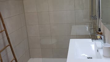 Chuveiro, secador de cabelo, toalhas de banho, papel higiênico